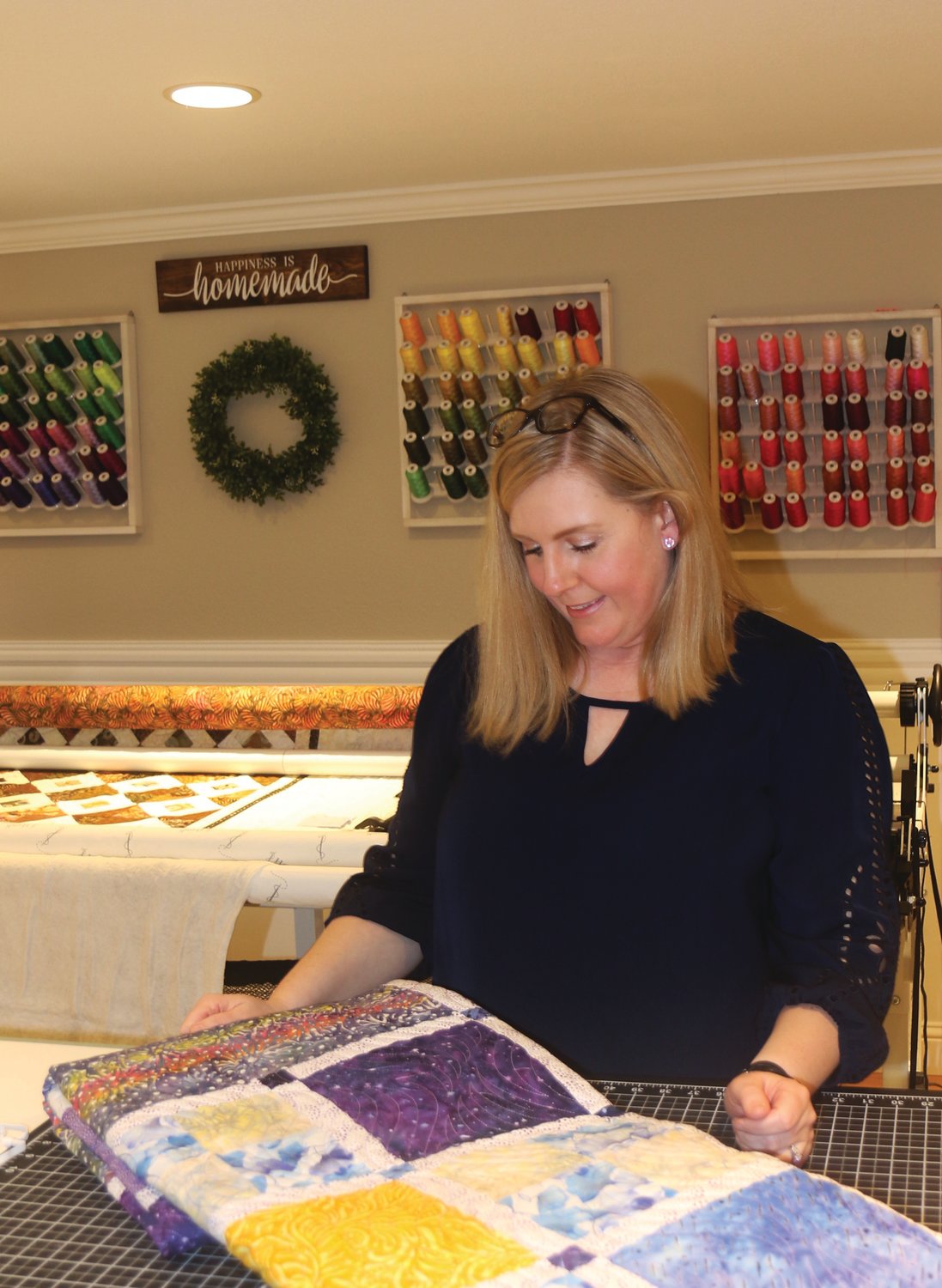 Life’s a Stitch business owner Pam Garlock assesses a finished quilt.